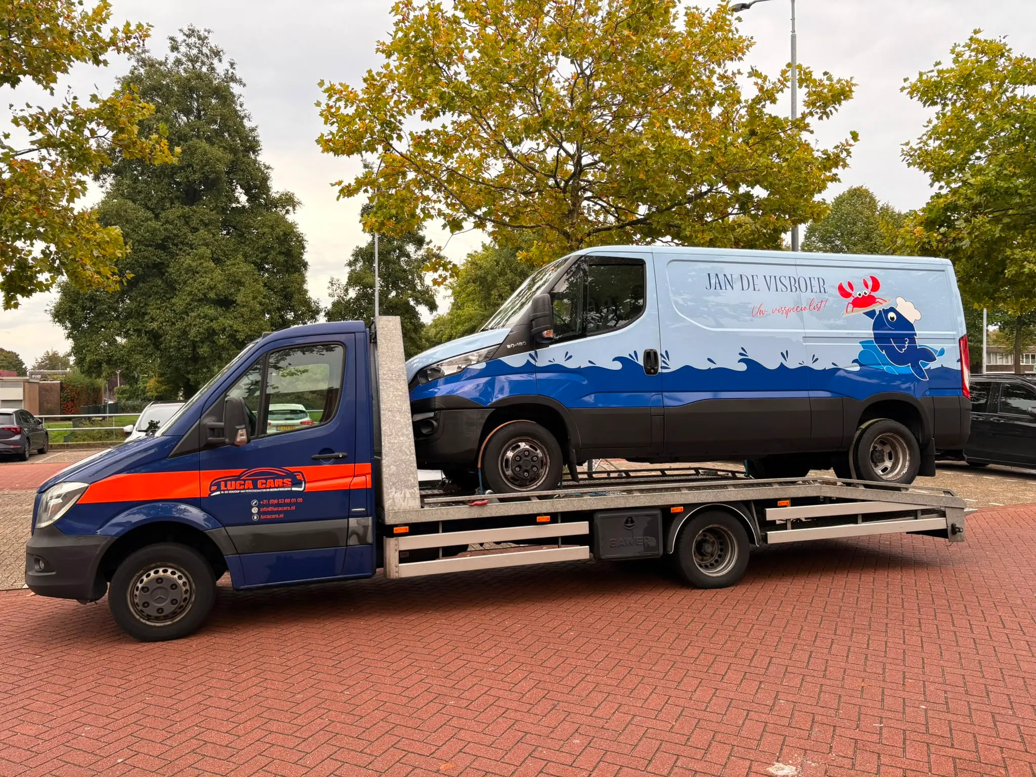 Bedrijfswagen van een visbedrijf op de autotransporter van Luca Cars