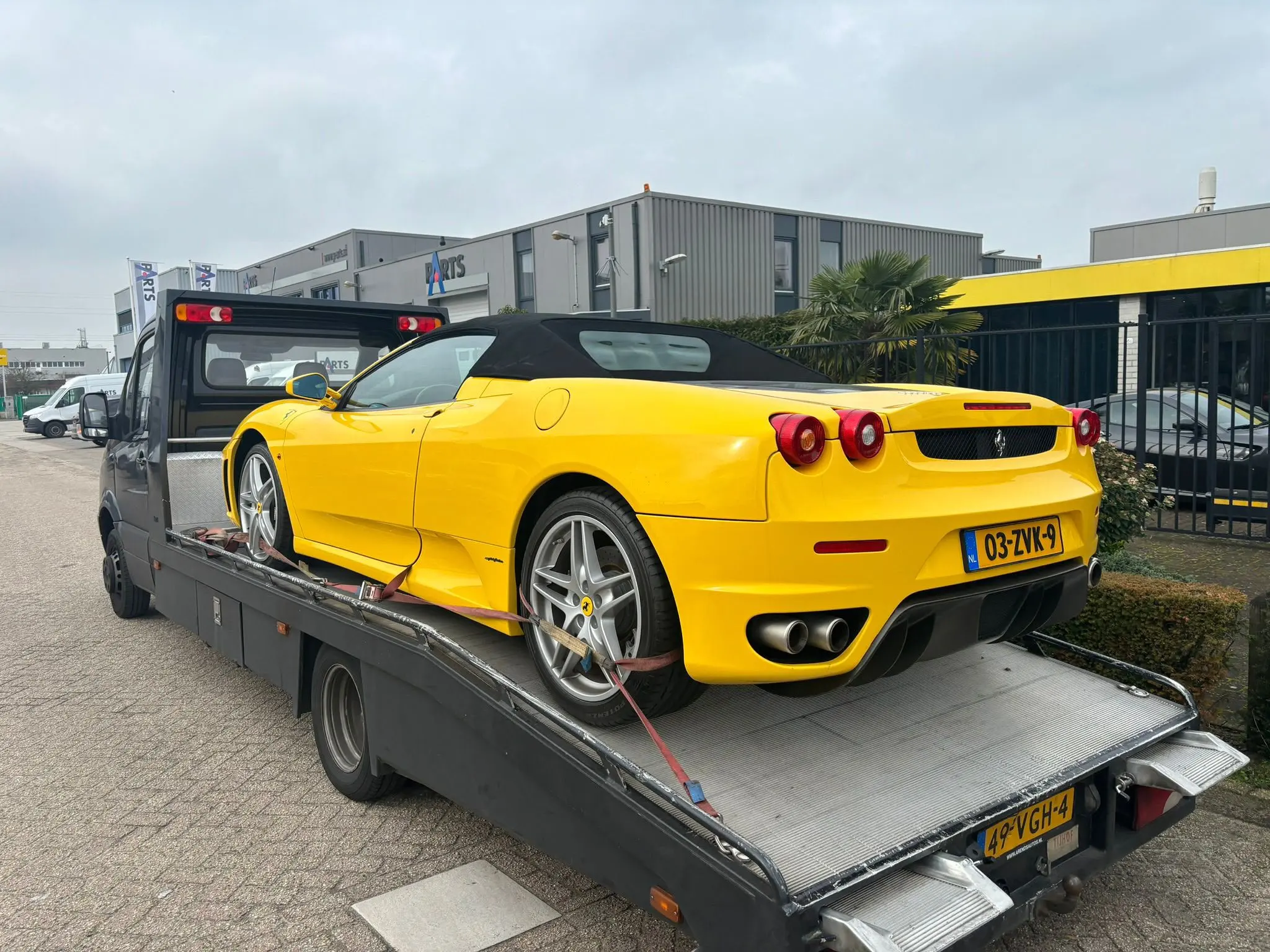 Gele Ferrari veilig vastgezet op een autotransporter