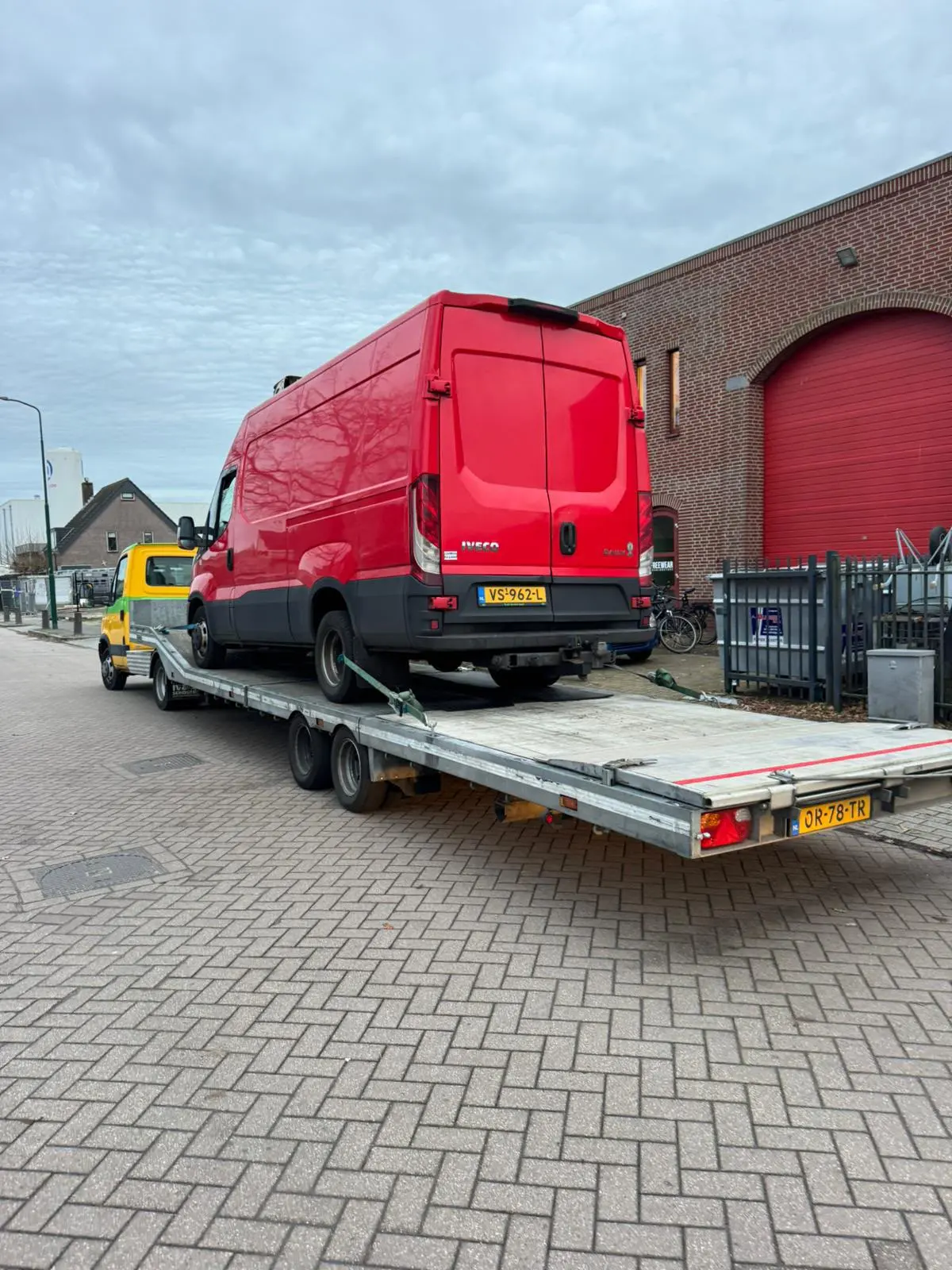 Rode bestelbus op een oprijwagen